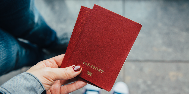 person holding two passports