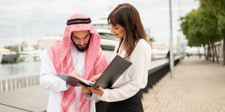jeune femme signant un contrat avec homme arabe