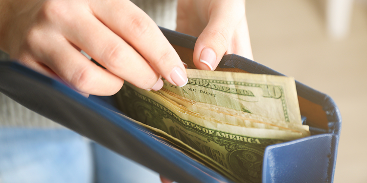 dollar notes in a blue purse