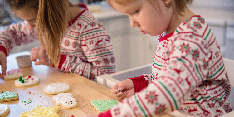two little girls decorating Christmas cookies