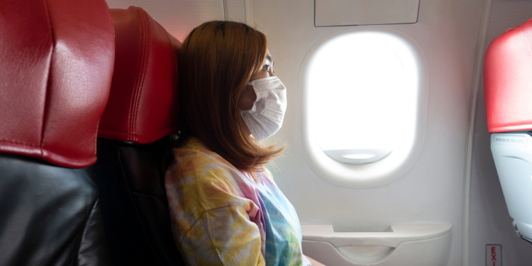 passager d'un avion portant un masque