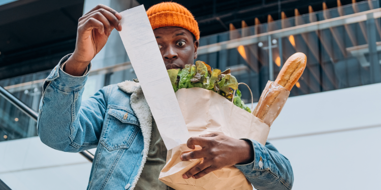 young man looking at shopping bill