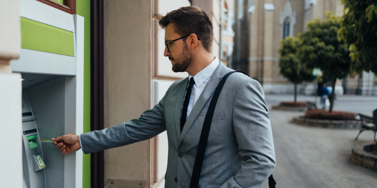 homme au guichet automatique