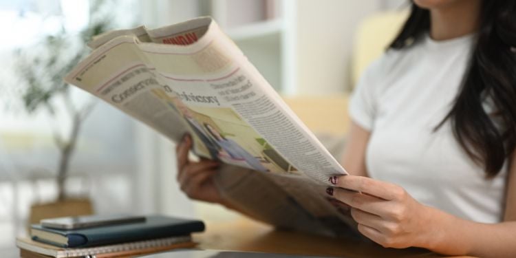 jeune femme lisant un journal
